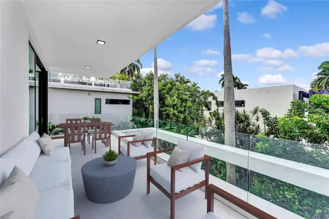 a view of a patio with table and chairs potted plants with floor to ceiling window and potted plants