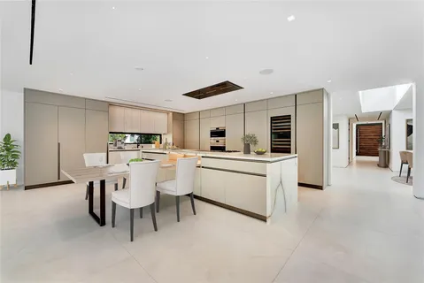 a kitchen with stainless steel appliances kitchen island granite countertop a sink and white cabinets