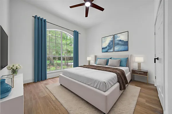 a bedroom with a large bed and a chandelier