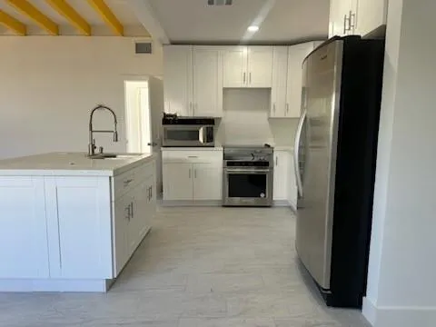 a kitchen with a refrigerator sink and cabinets
