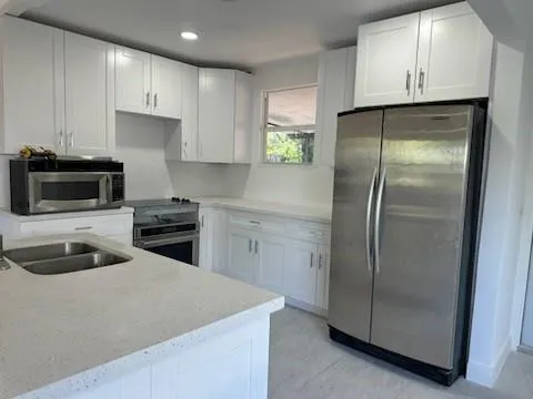 a kitchen with a refrigerator sink and cabinets