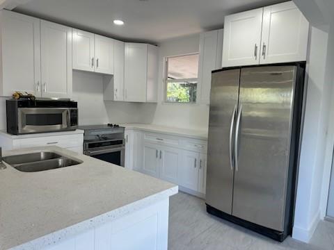 821 North B Street Lake Worth Beach, FL 33460 - Photo 6 of 9 a kitchen with a refrigerator sink and cabinets