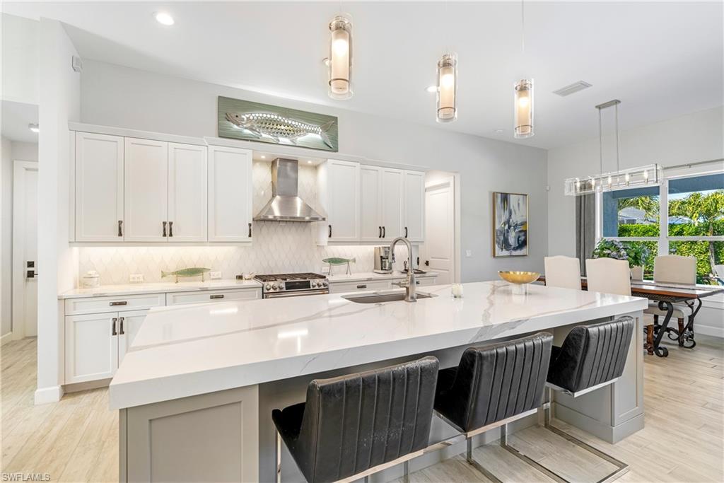 29 Johnnycake Drive Naples, FL 34110 - Photo 12 of 42 a kitchen with a stove a sink a dining table and chairs