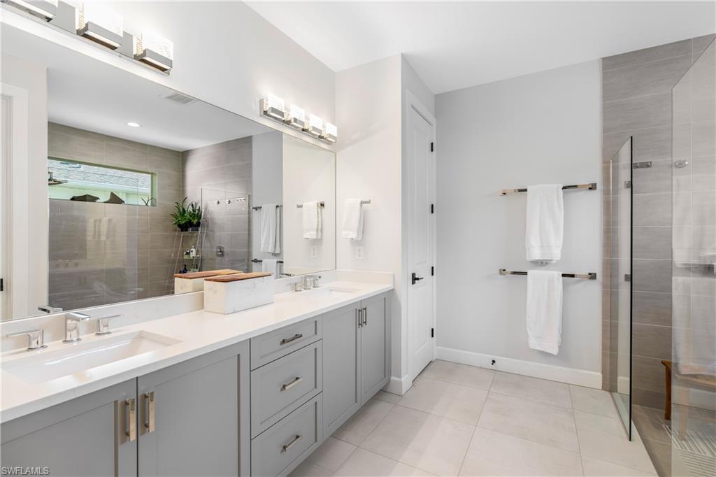 29 Johnnycake Drive Naples, FL 34110 - Photo 19 of 42 a spacious bathroom with a double vanity sink mirror and double