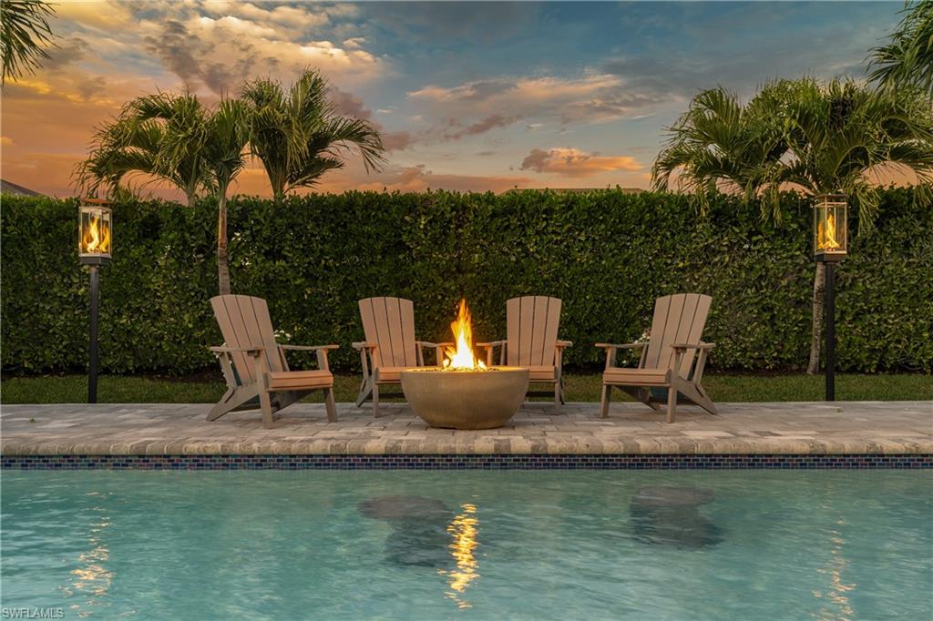 29 Johnnycake Drive Naples, FL 34110 - Photo 2 of 42 a view of a table and chairs on the roof deck