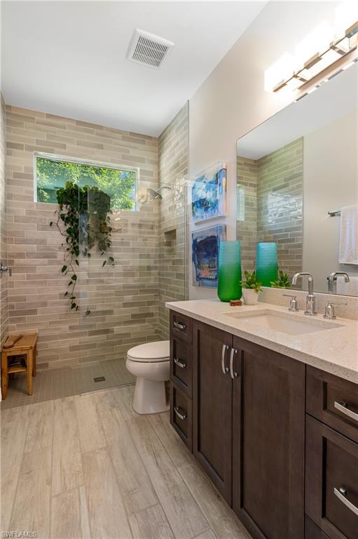 29 Johnnycake Drive Naples, FL 34110 - Photo 23 of 42 a bathroom with a sink a toilet and mirror