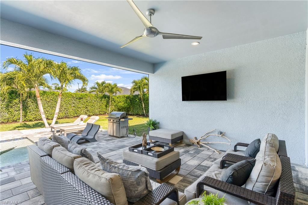 29 Johnnycake Drive Naples, FL 34110 - Photo 28 of 42 a living room with furniture a large window and a flat screen tv