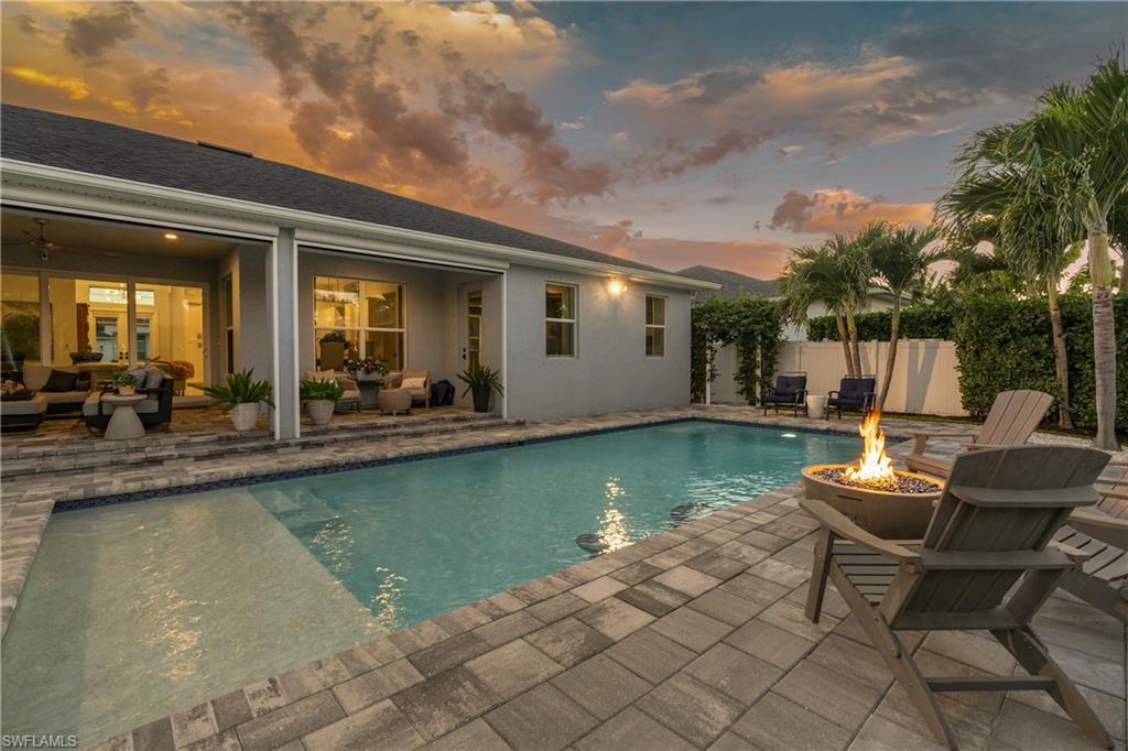 29 Johnnycake Drive Naples, FL 34110 - Photo 32 of 42 a view of a patio with dining table and chairs with a swimming pool