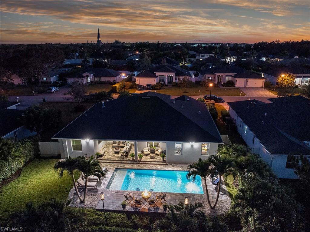 29 Johnnycake Drive Naples, FL 34110 - Photo 37 of 42 a view of a swimming pool with lawn chairs under an umbrella