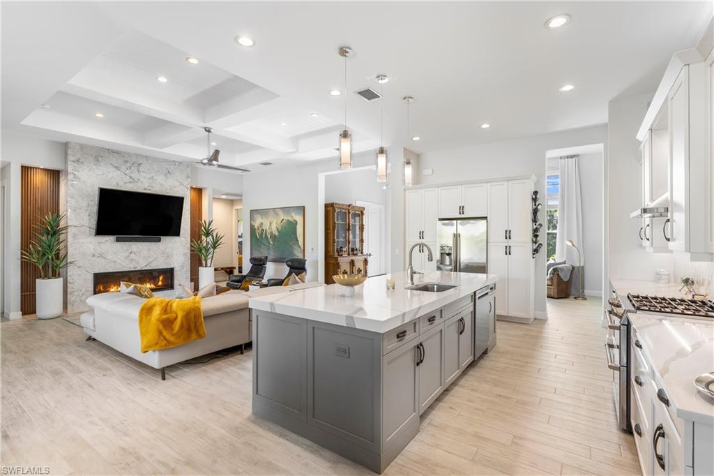 29 Johnnycake Drive Naples, FL 34110 - Photo 10 of 42 a large kitchen with stainless steel appliances lots of white furniture and a flat screen tv