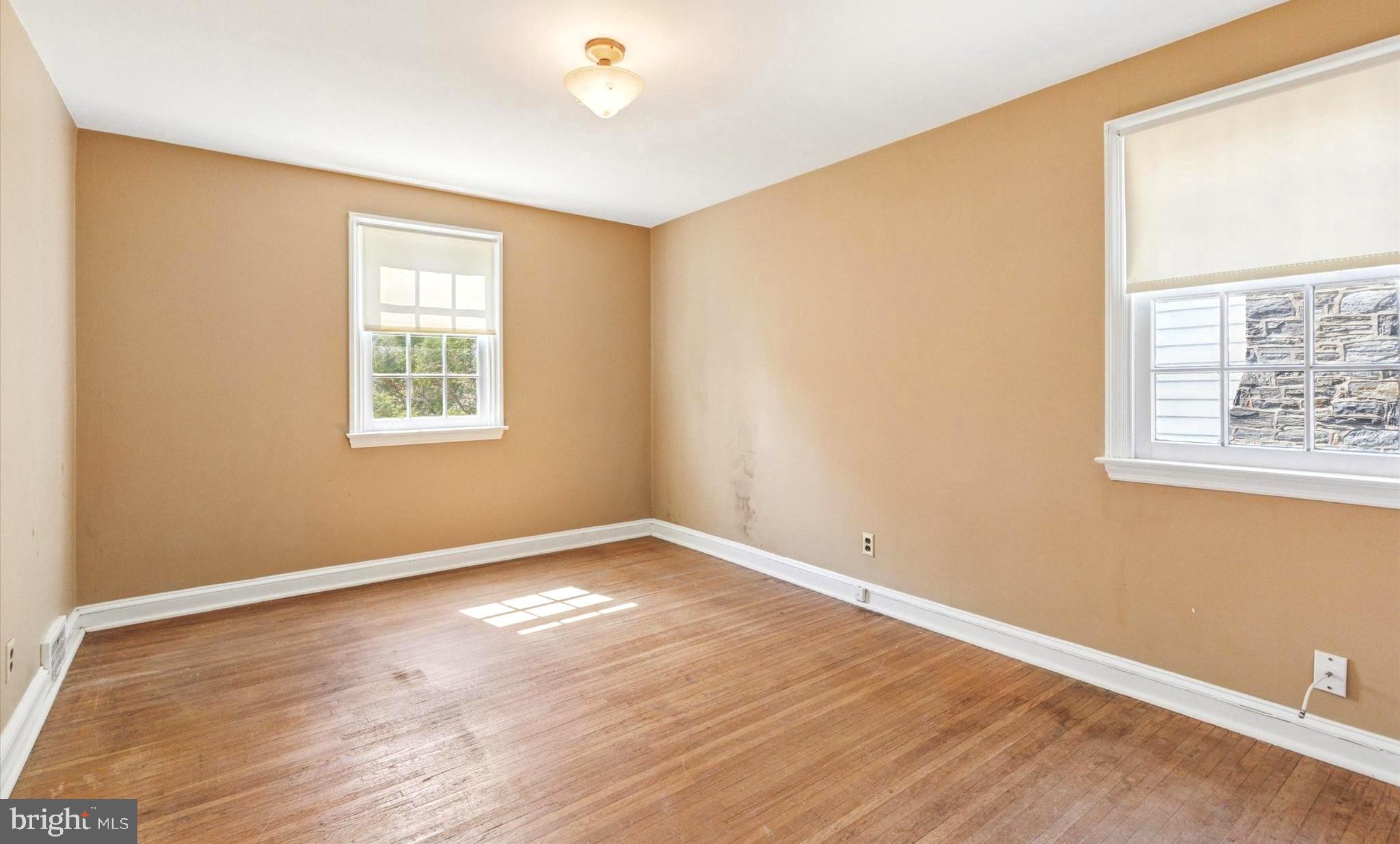 219 Williamsburg Road Ardmore, PA 19003 - Photo 11 of 14 an empty room with wooden floor and windows