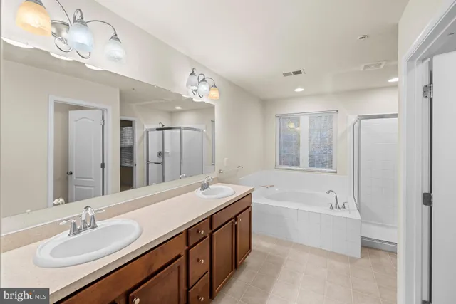a bathroom with a tub double sink shower and mirror