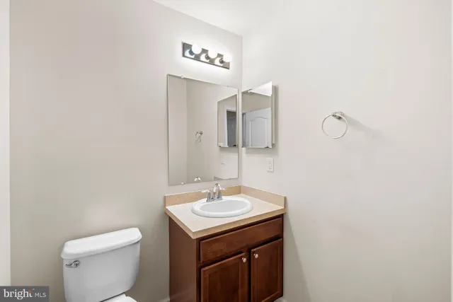 a bathroom with a toilet a sink and mirror