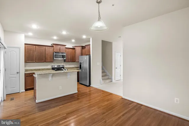 a kitchen with stainless steel appliances granite countertop a refrigerator a stove top oven a sink and dishwasher