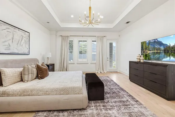 a bedroom with a large bed and a chandelier
