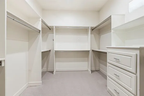 a view of walk in closet with empty racks