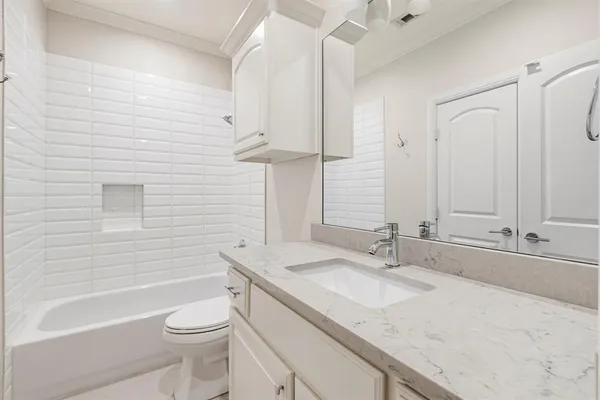 a bathroom with a granite countertop sink a toilet and bathtub