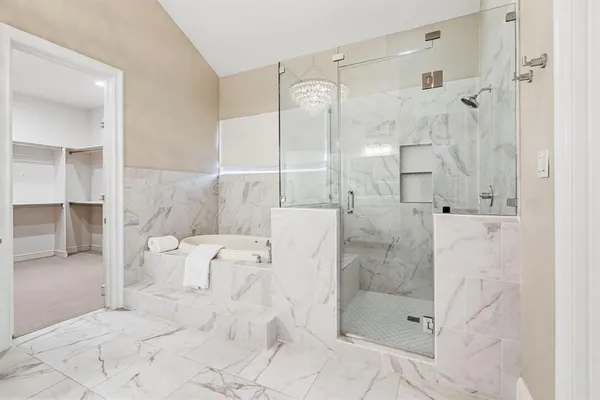 a bathroom with a bathtub shower sink and mirror
