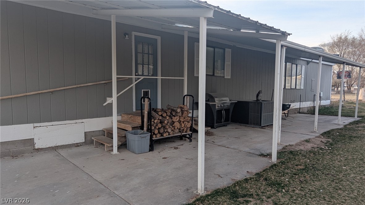 320 6th Street Panaca, NV 89042 - Photo 24 of 30 Back of house with a lawn, a patio area, and a metal roof