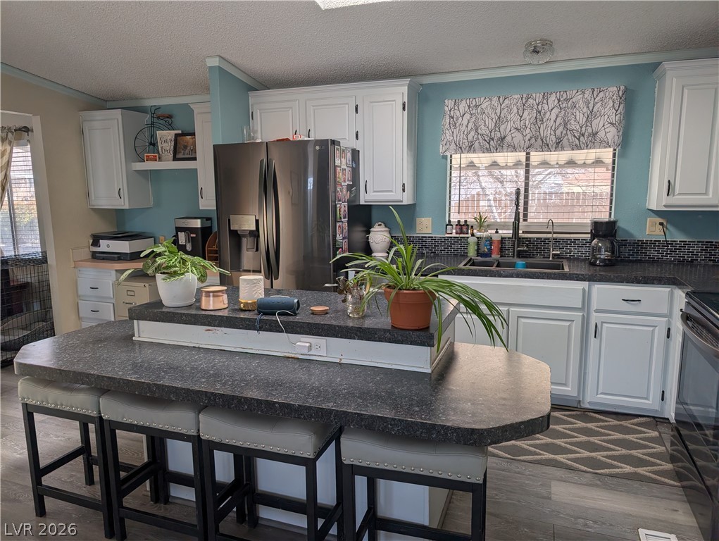 320 6th Street Panaca, NV 89042 - Photo 10 of 30 Kitchen with healthy amount of natural light, white cabinets, a textured ceiling, and stainless steel fridge