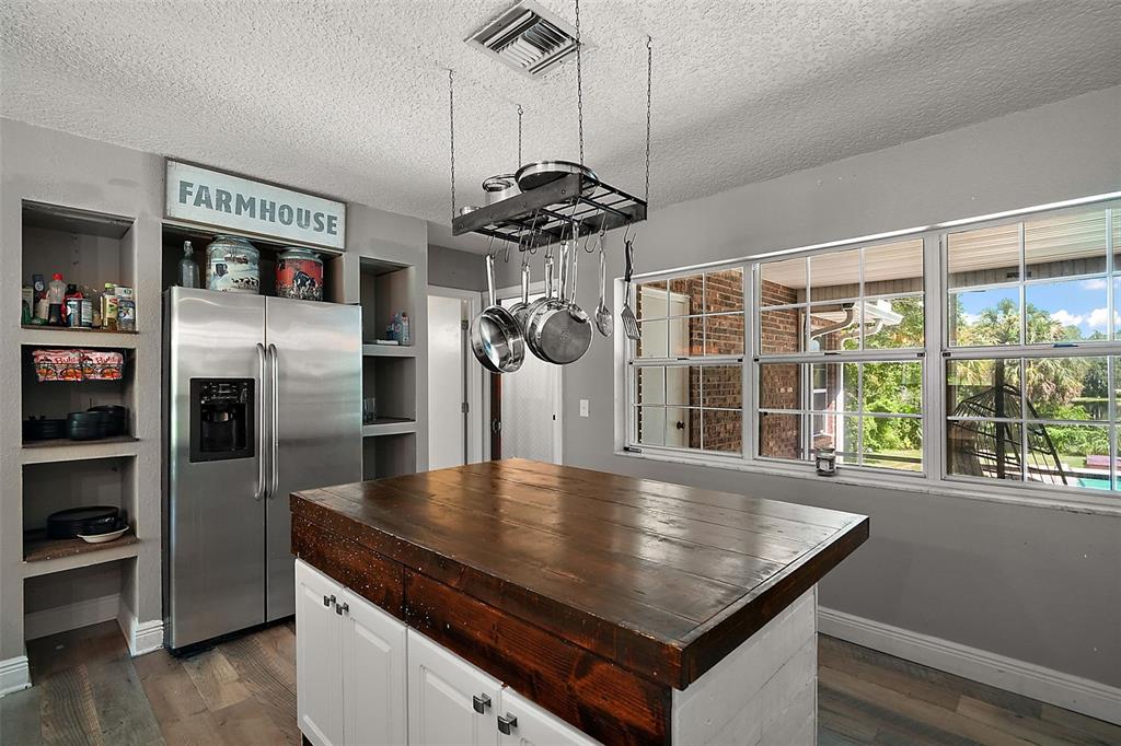 705 West Summit Court Mount Dora, FL 32757 - Photo 11 of 37 a kitchen with stainless steel appliances granite countertop a refrigerator a stove and a sink with wooden floor