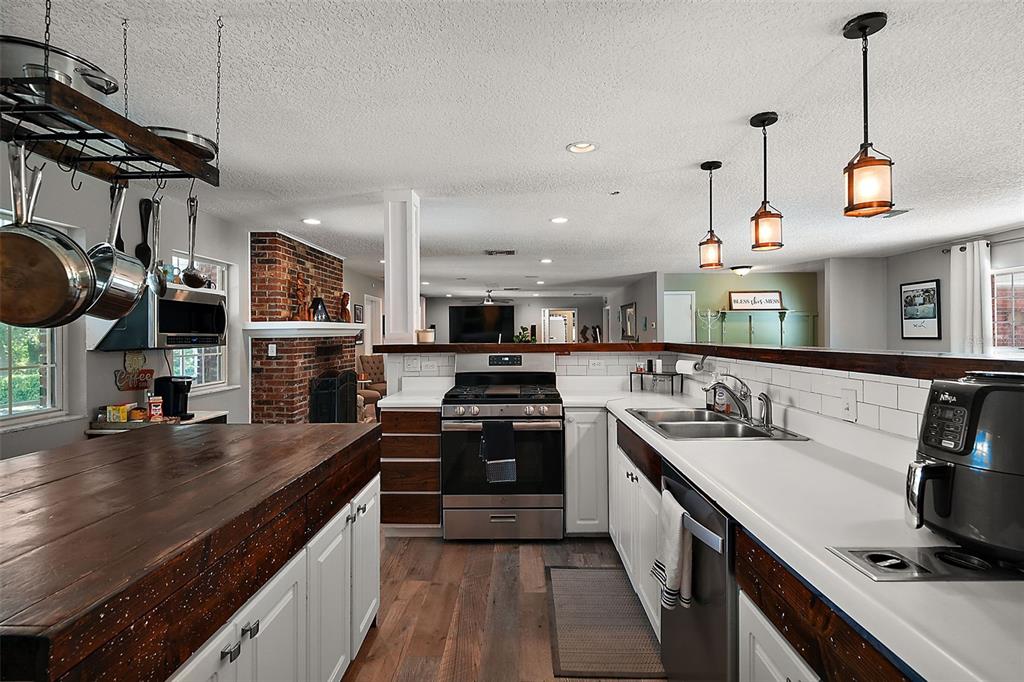 705 West Summit Court Mount Dora, FL 32757 - Photo 13 of 37 a kitchen with stainless steel appliances granite countertop a sink a stove and a wooden floors
