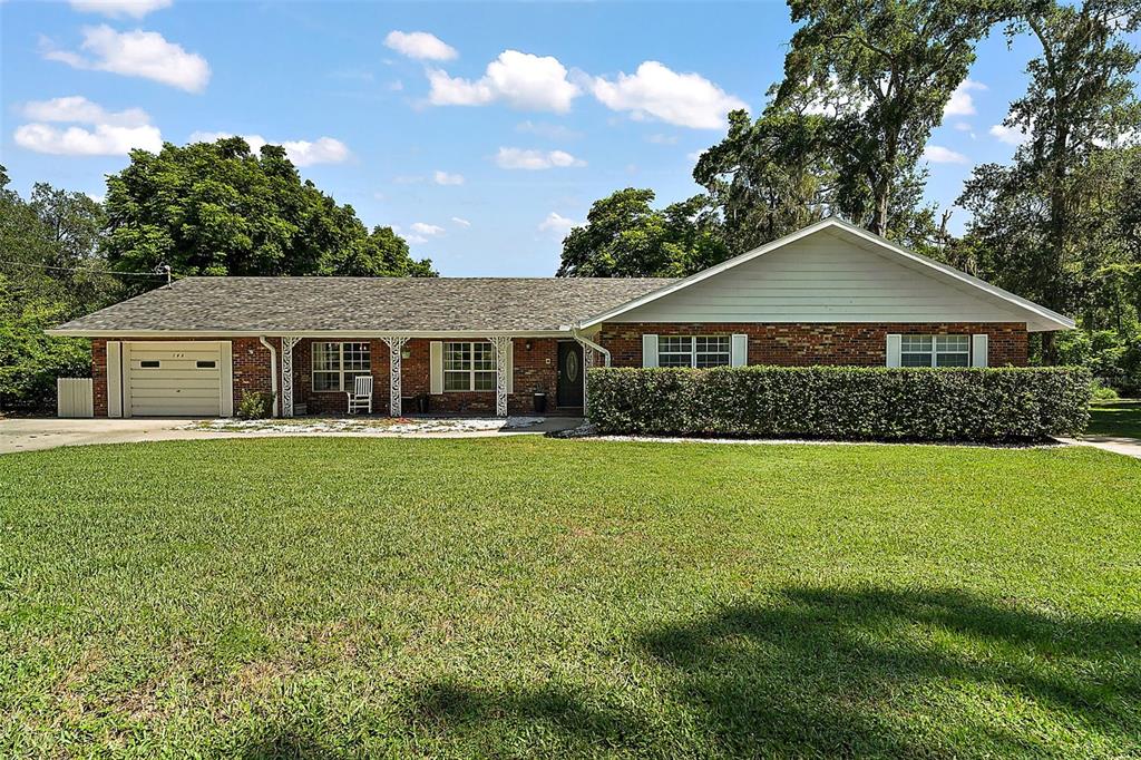 705 West Summit Court Mount Dora, FL 32757 - Photo 2 of 37 a front view of a house with a garden