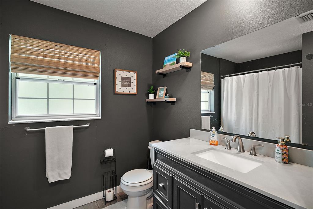 705 West Summit Court Mount Dora, FL 32757 - Photo 24 of 37 a bathroom with a granite countertop toilet sink and mirror