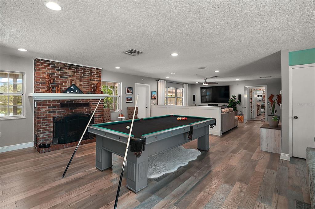 705 West Summit Court Mount Dora, FL 32757 - Photo 6 of 37 a living room with furniture a wooden floor and a fireplace