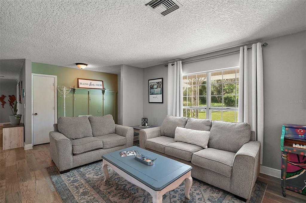 705 West Summit Court Mount Dora, FL 32757 - Photo 8 of 37 a living room with furniture and a large window