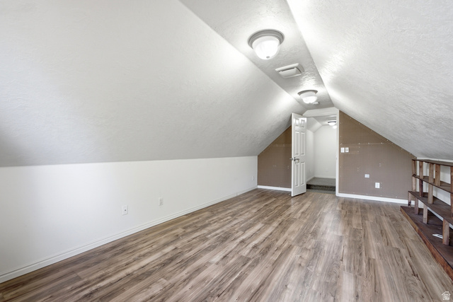 5196 Rodeo Circle Oakley, UT 84055 - Photo 30 of 57 Attic space featuring wood-finish flooring, sloped white ceilings, and recessed lighting fixtures