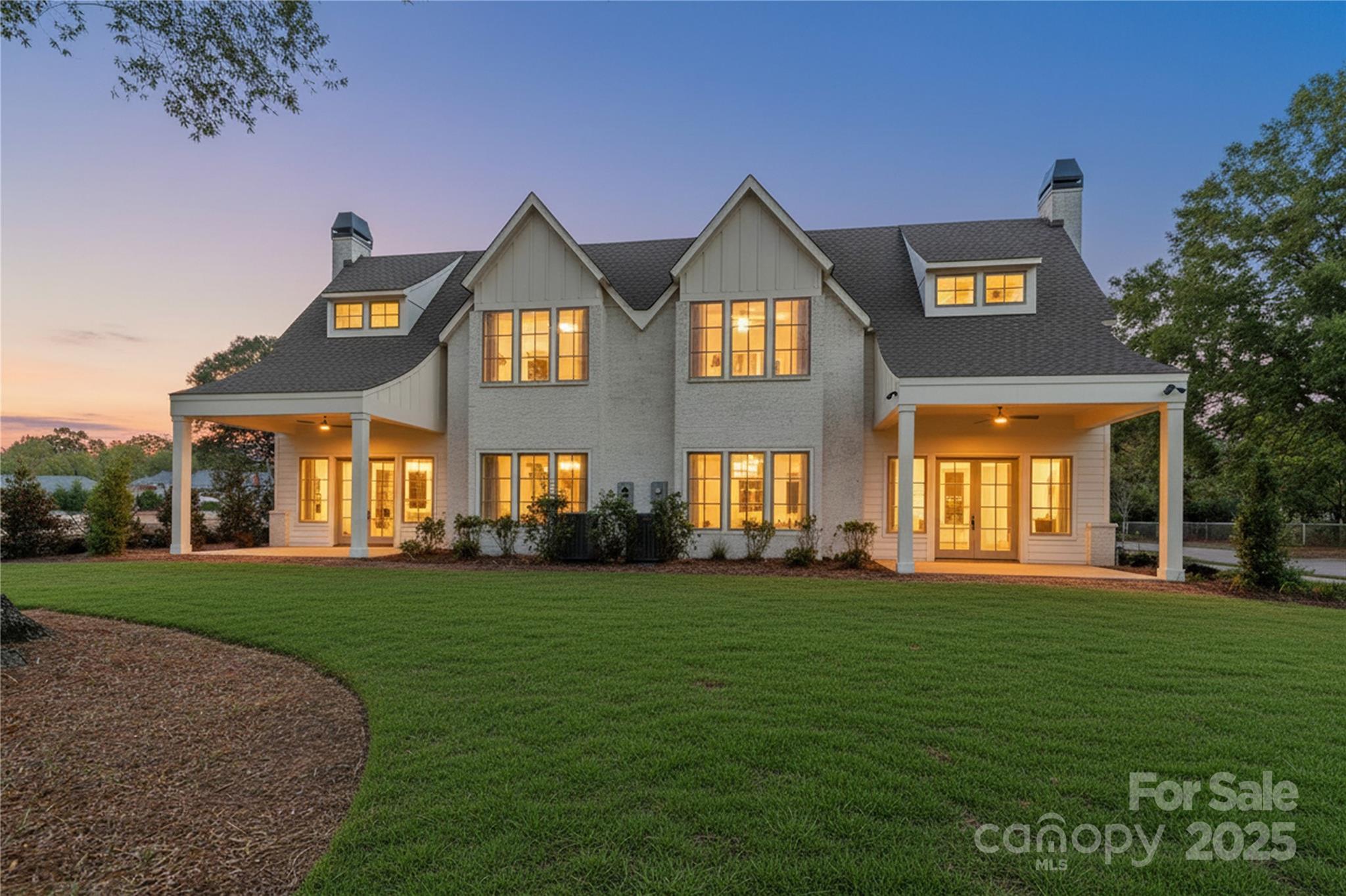 a view of a big house with a big yard and potted plants