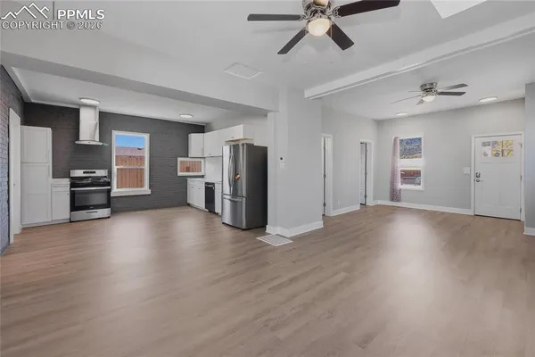 a view of empty room with a kitchen and wooden floor