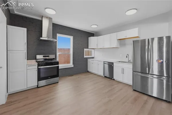 a kitchen with a refrigerator and a stove top oven