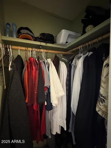 a view of walk in closet with clothes and shoes