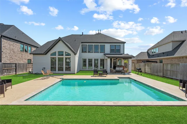 a view of a house with pool and a yard