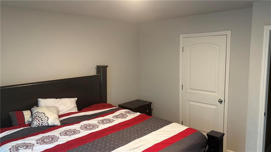 4475 Merrigold Way Fairburn, GA 30213 - Photo 17 of 22 a bedroom with a bed and a lamp