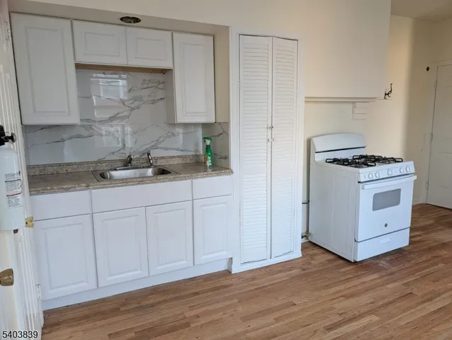 a kitchen with stainless steel appliances granite countertop a sink stove and wooden floor