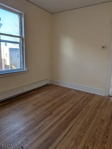 a view of a room that has wooden floor and more window
