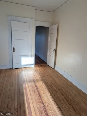 an empty room with wooden floor and closet