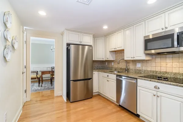 a kitchen with granite countertop a refrigerator stove and microwave