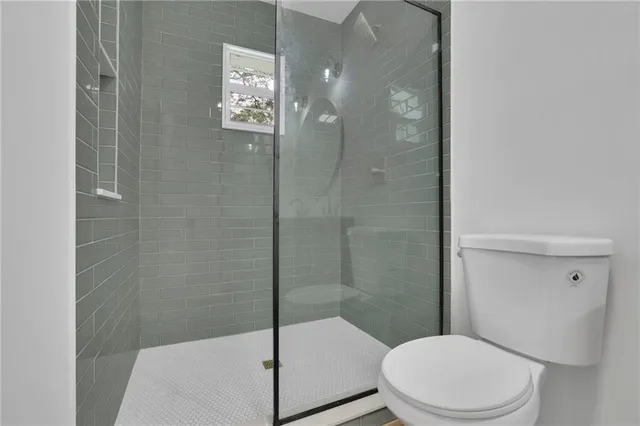 a white toilet next to a bathroom