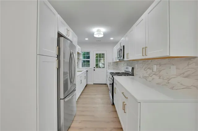 a kitchen with stainless steel appliances granite countertop a refrigerator and a stove