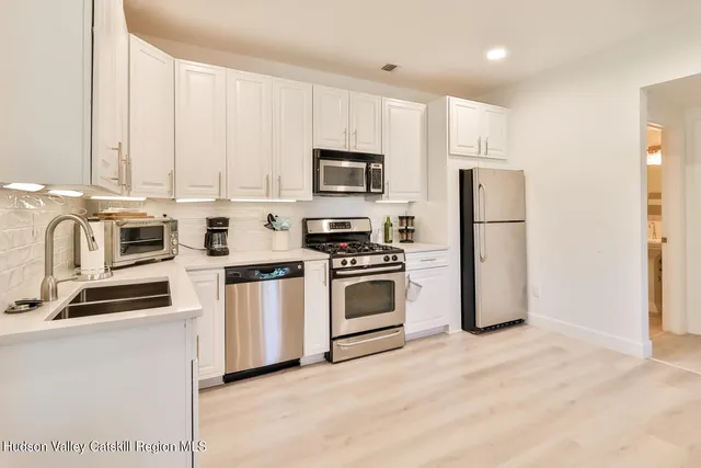a kitchen with cabinets stainless steel appliances and a counter top space