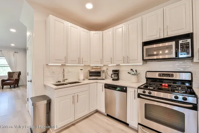 a kitchen with cabinets appliances a sink and a counter top space
