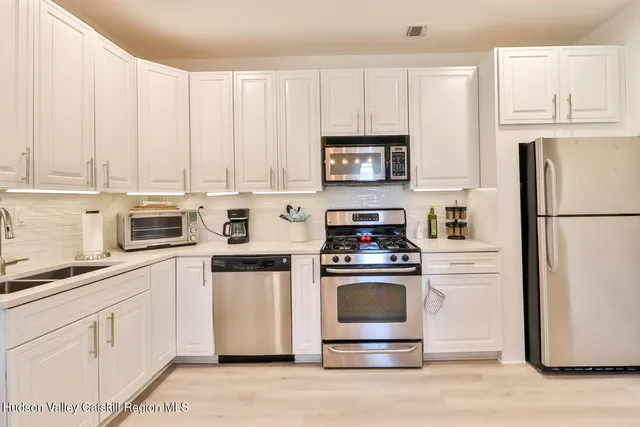 a kitchen with white cabinets and white appliances