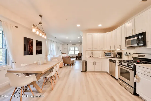 a kitchen with a sink stainless steel appliances and white cabinets