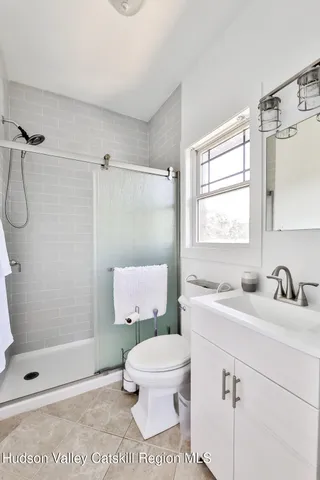 a bathroom with a sink toilet a mirror and shower