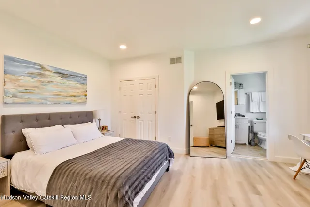 a bedroom with a bed and a painting on the wall