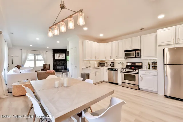 a large kitchen with white cabinets table and chairs